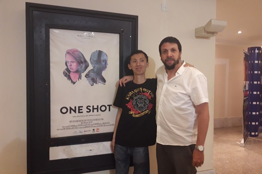 El realizador Sergio Mazza (a la derecha), junto al afiche de su película. 